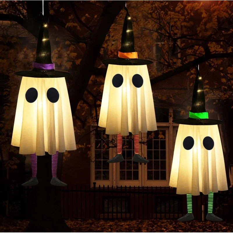 Outdoor Halloween ghost lights with witch hat decorations glowing in garden